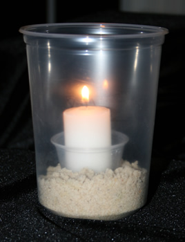 Clear bucket with lit candle